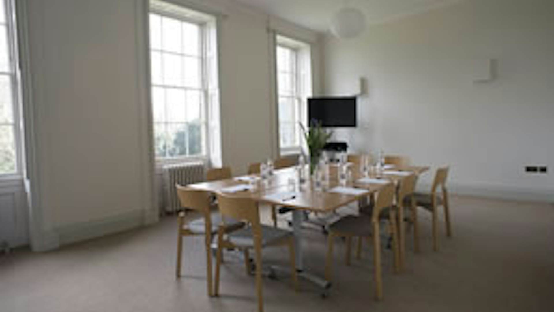 Well-lit meeting room with minimalist decor, perfect for workshops in Hackney Venues.
