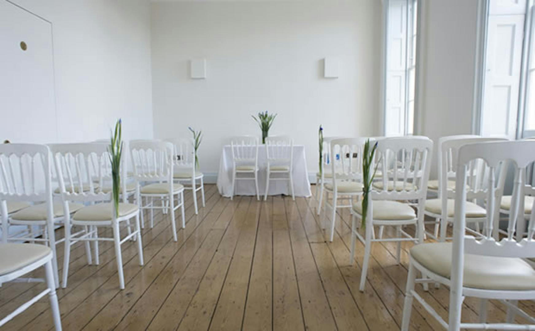 Minimalist event space with white chairs for meetings in Hackney Venues.