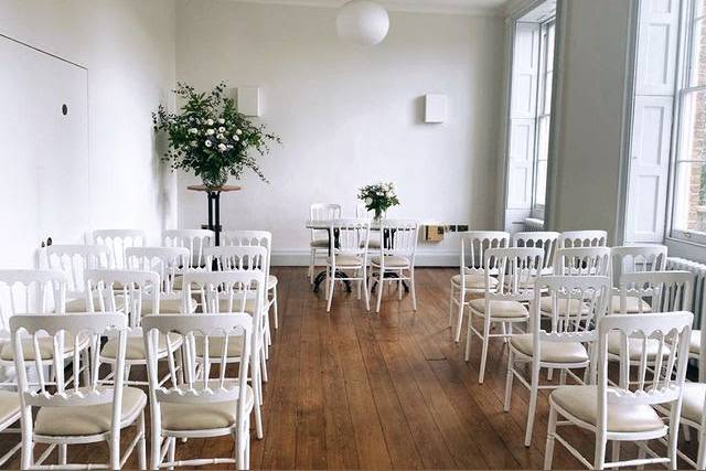 Minimalist event space with white chairs for meetings in Hackney Venues.