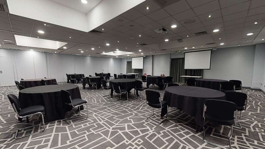 Meeting room at Village Hotel Bury, featuring round tables for conferences and events.