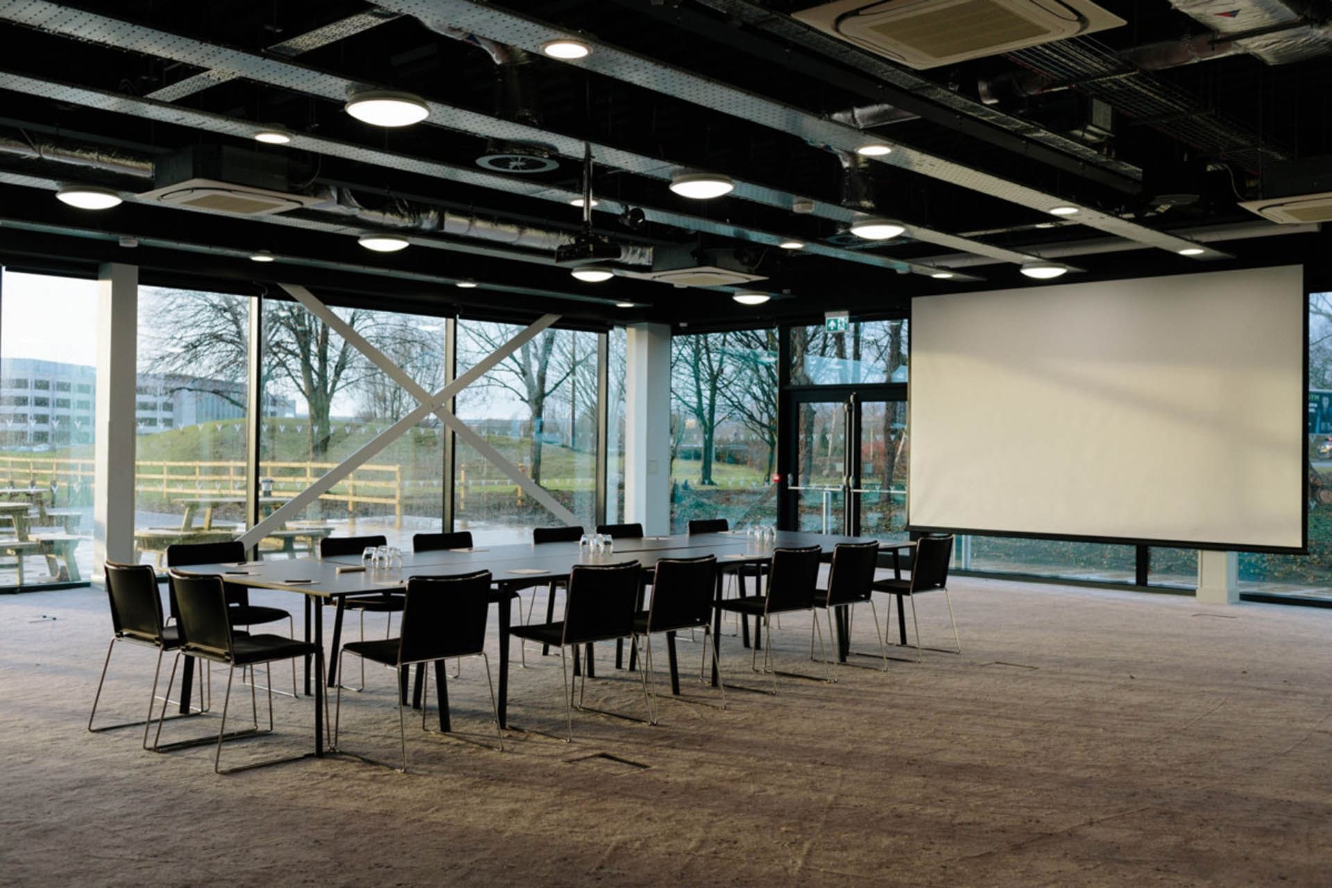 Modern meeting room with large table and natural light at Village Hotel Bury for workshops.