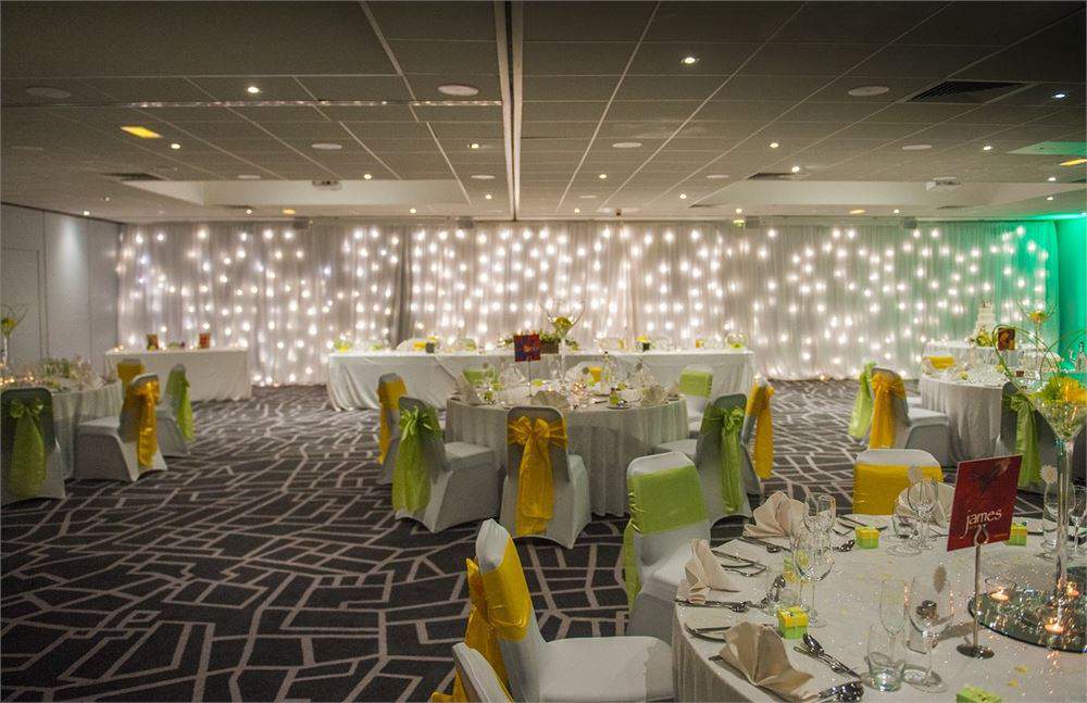 Inspiration Suites event space with elegant tables and vibrant chair sashes for celebrations.