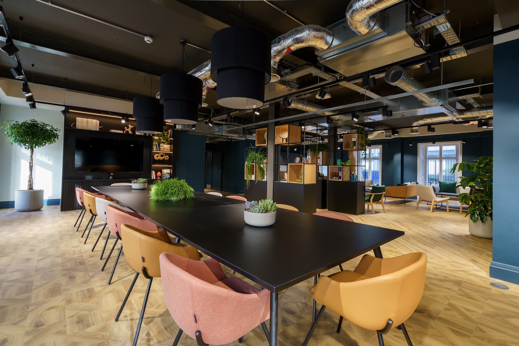 Modern meeting space with long table and natural light for workshops and events.