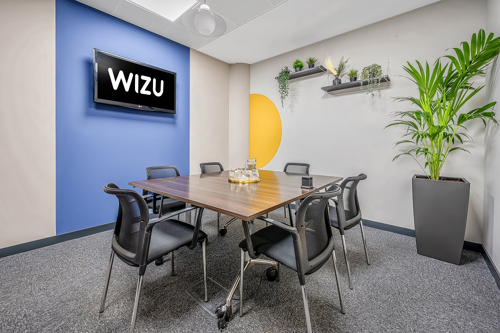 Modern meeting room in Wizu Workspace with ergonomic chairs and vibrant decor.