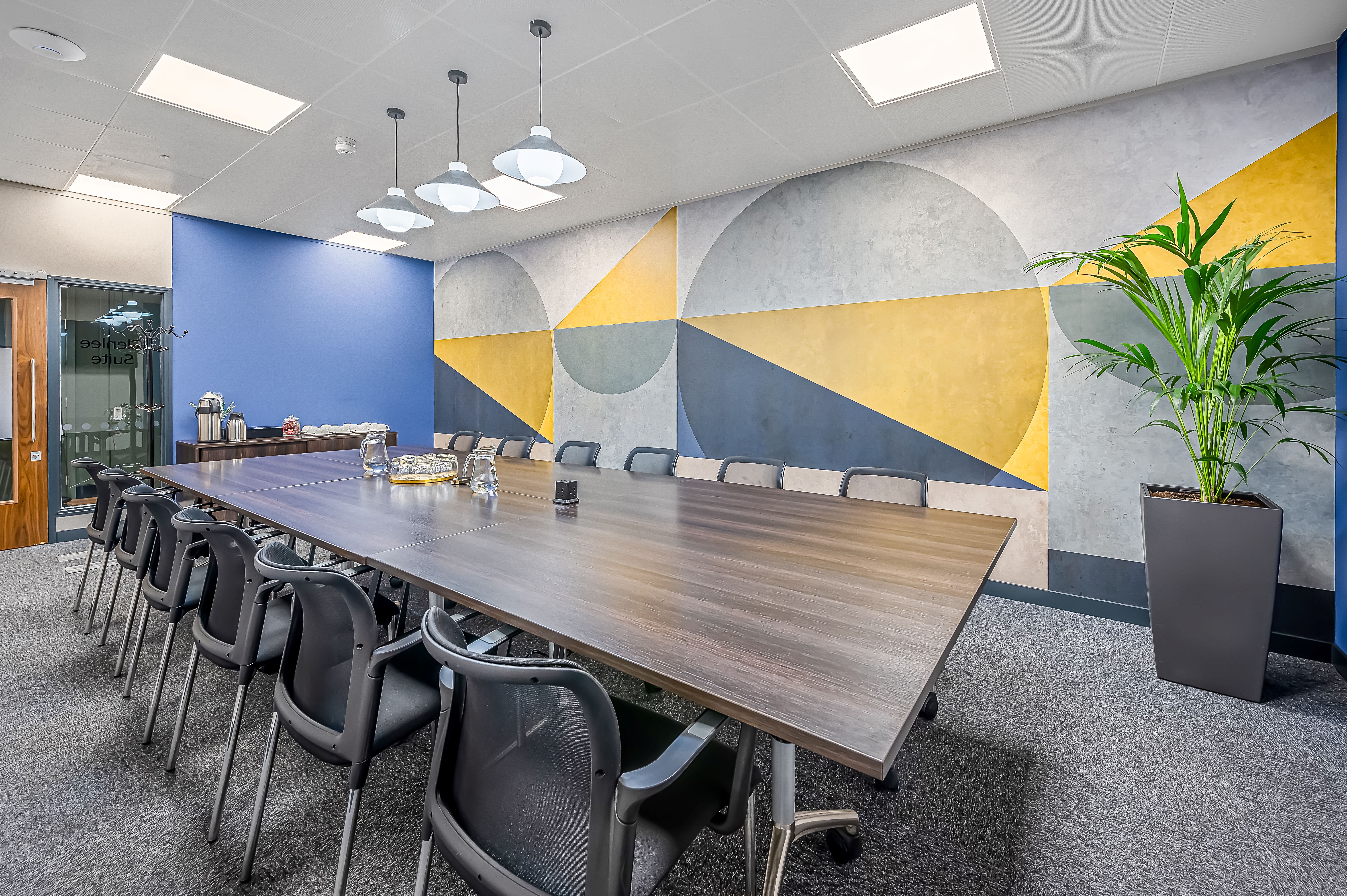 Modern meeting room with wooden table, ideal for brainstorming and executive meetings.