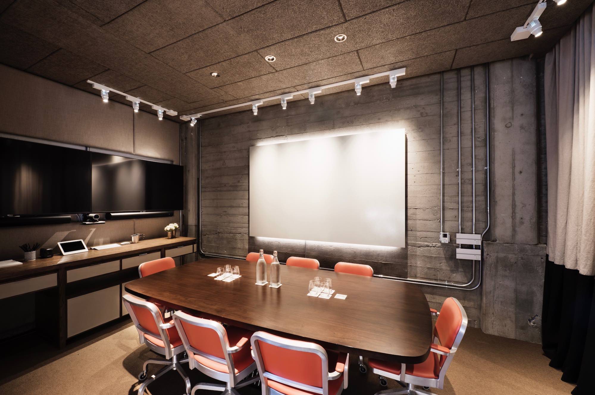 Modern screening room with wooden table, ideal for meetings and collaboration.