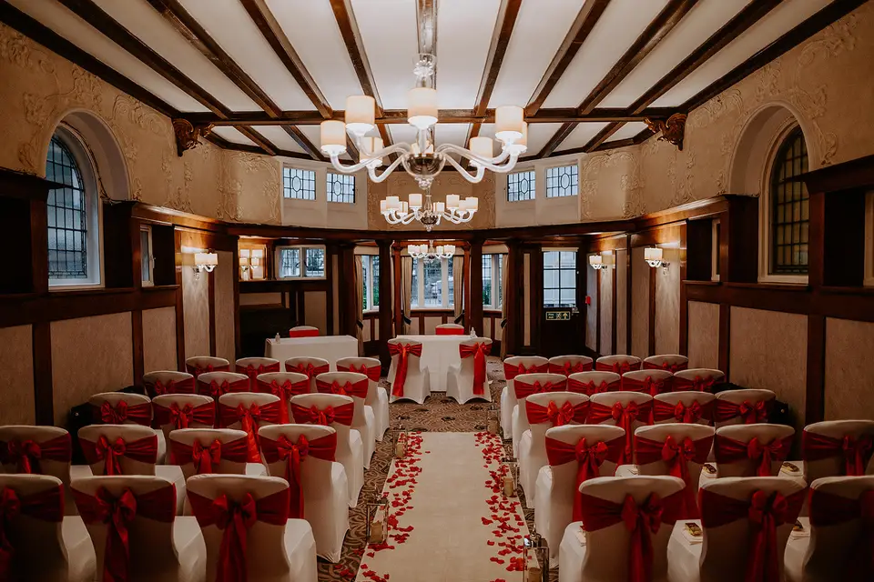 Elegant event space in Richmond Hill Hotel with red-sashed chairs for weddings.