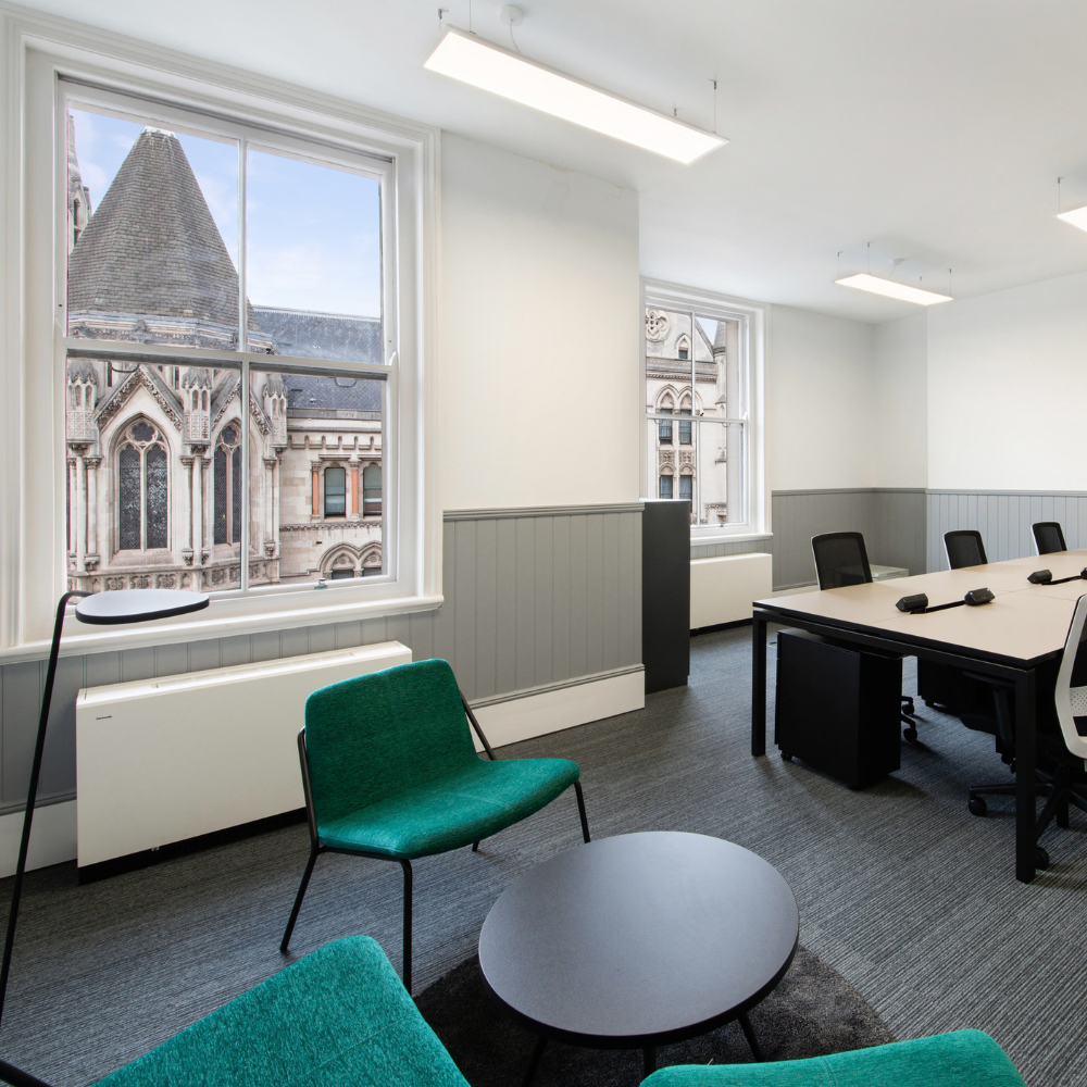 Modern meeting room with large table and green chair, perfect for collaboration events.