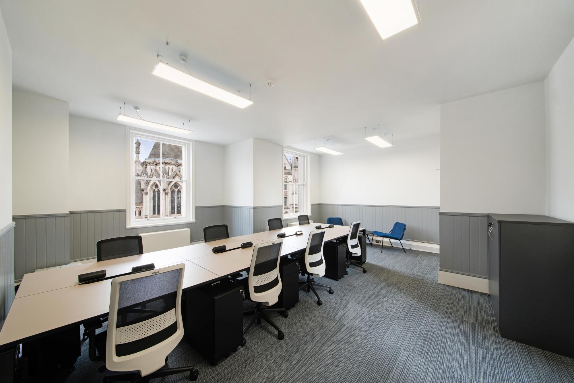 Modern meeting room with large table, ideal for workshops and strategy sessions.