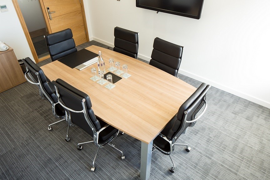 Modern conference room with wooden table and ergonomic chairs for productive meetings.