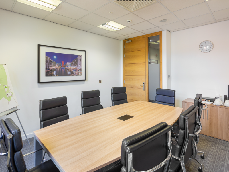 Modern meeting room with wooden table, ideal for corporate events and brainstorming sessions.