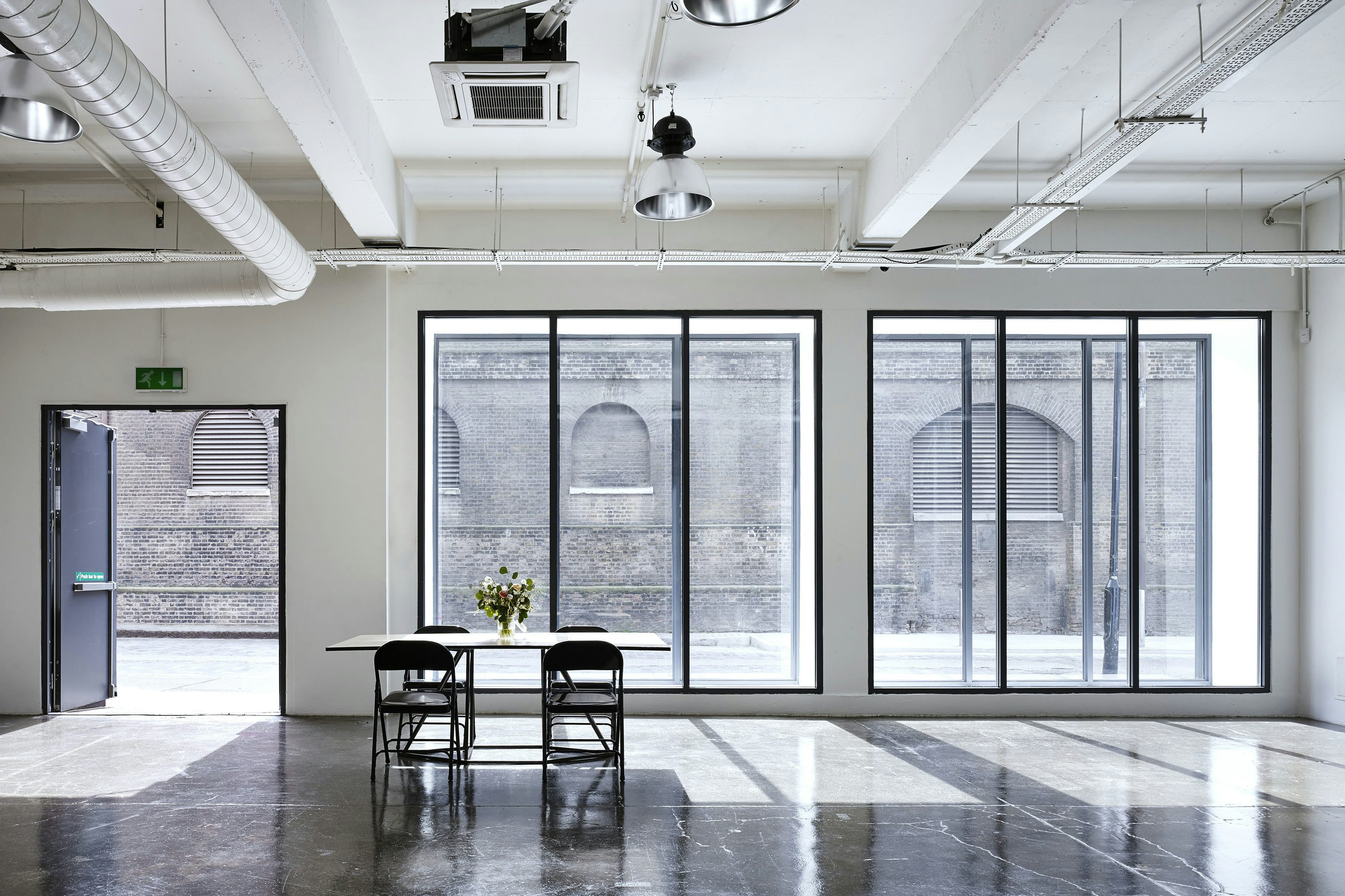 Modern meeting room with large windows, perfect for workshops and events.