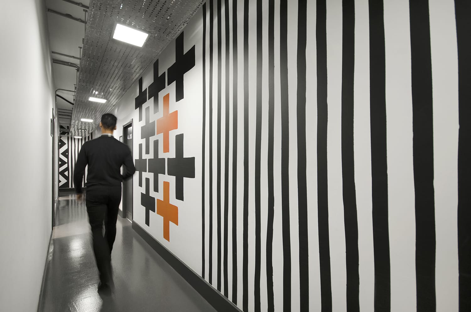 Modern hallway with bold black and white stripes, perfect for creative events.