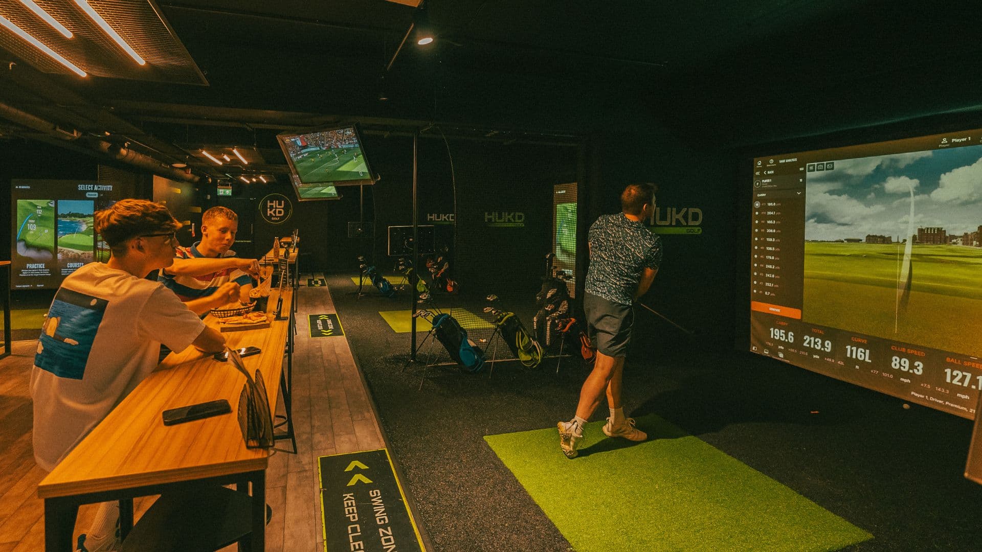 HUKD golf simulator venue with lounge area for corporate team building and networking events.