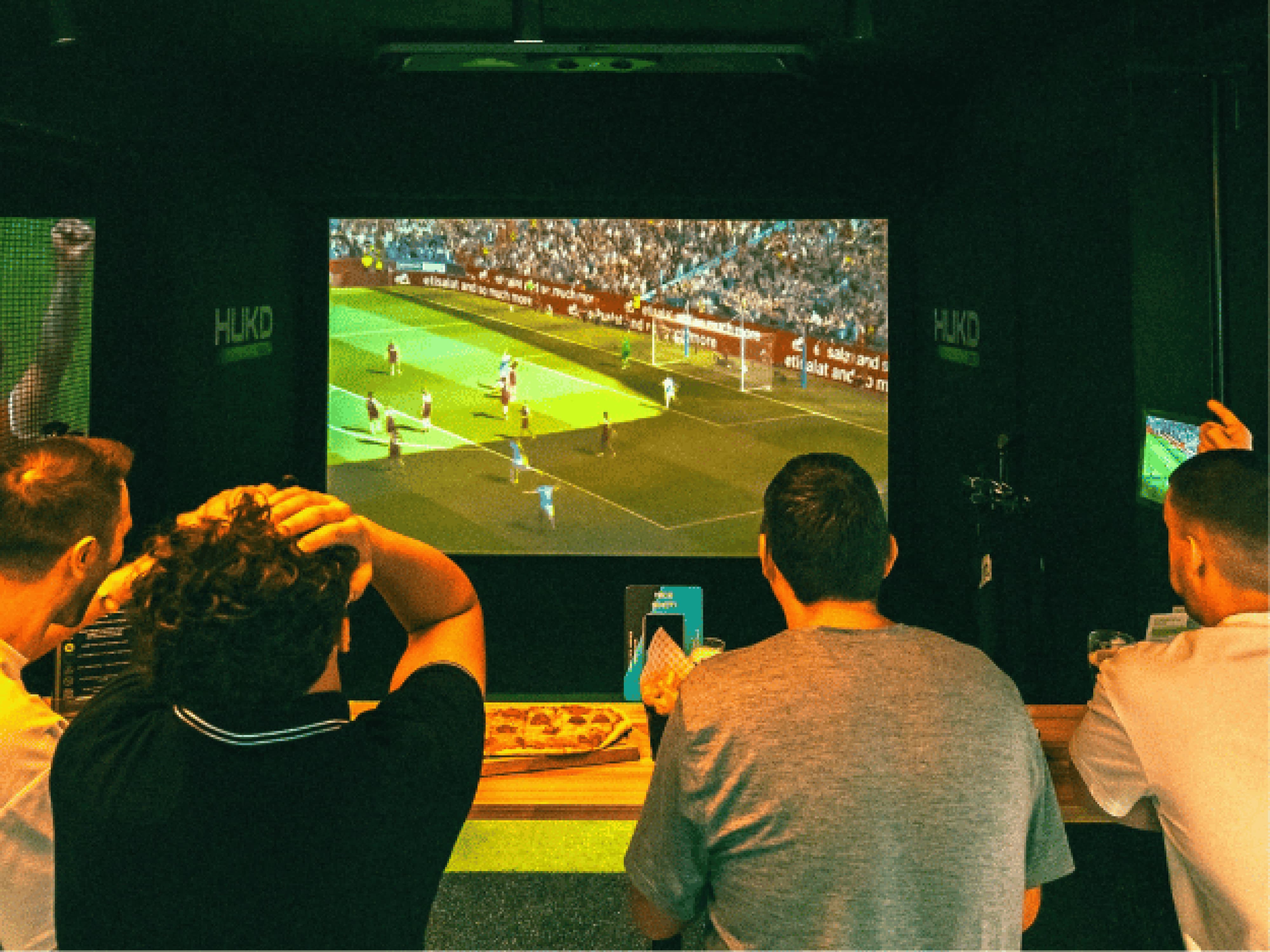 HUKD Golf simulator setup, immersive virtual gaming screen, indoor golf event, corporate entertainment.