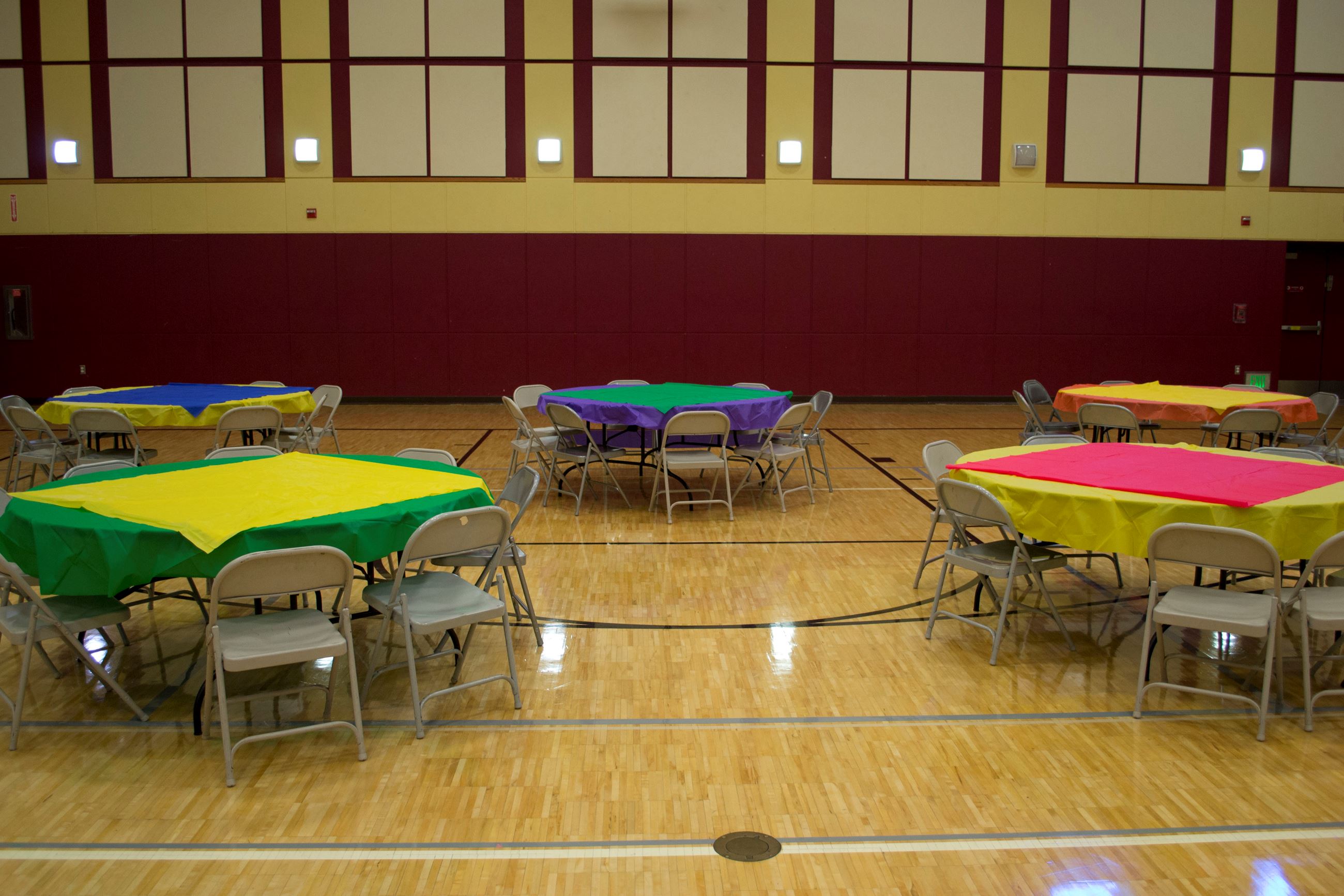 Spacious Bayshore Community Center activity room with vibrant tables for community events.