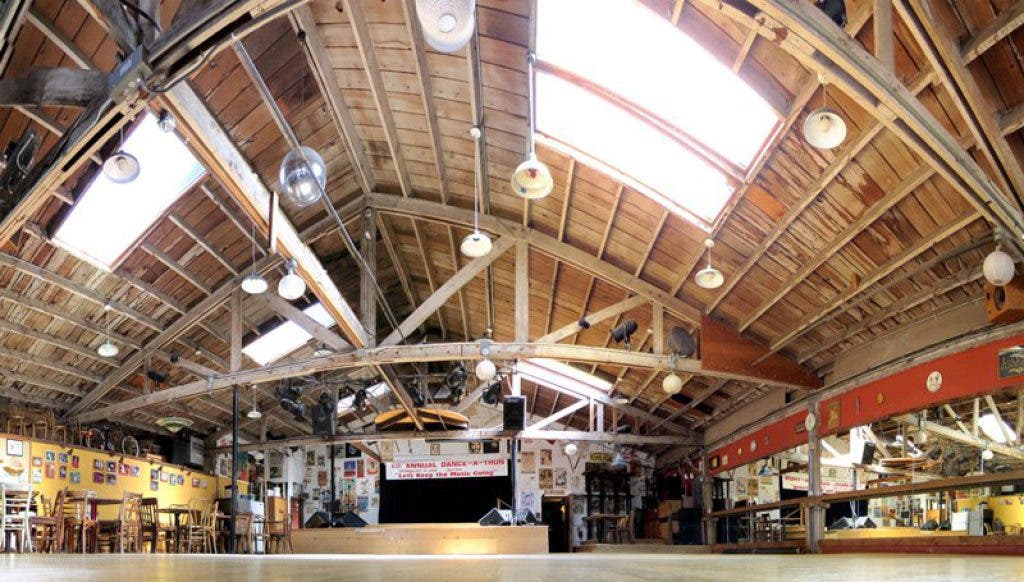 Spacious Front Dance Hall with wooden ceilings, ideal for events and performances.