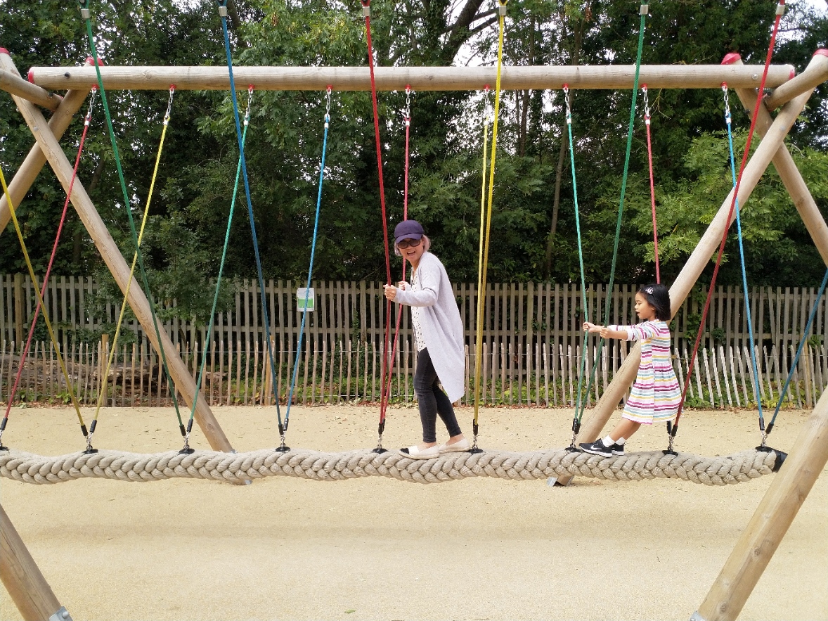 Playground in Holland Park with swings, perfect for family events and community gatherings.