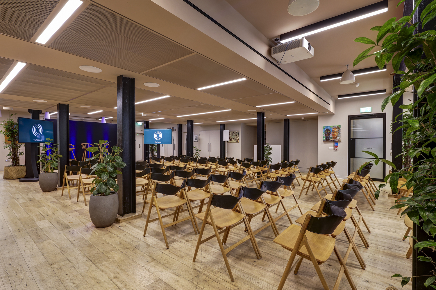 Event space at The Forum with wooden chairs, ideal for presentations and seminars.