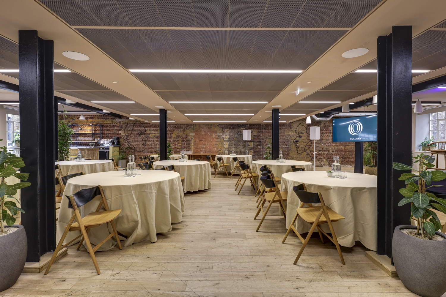 The Forum in The Conduit: modern event space with round tables for meetings and gatherings.