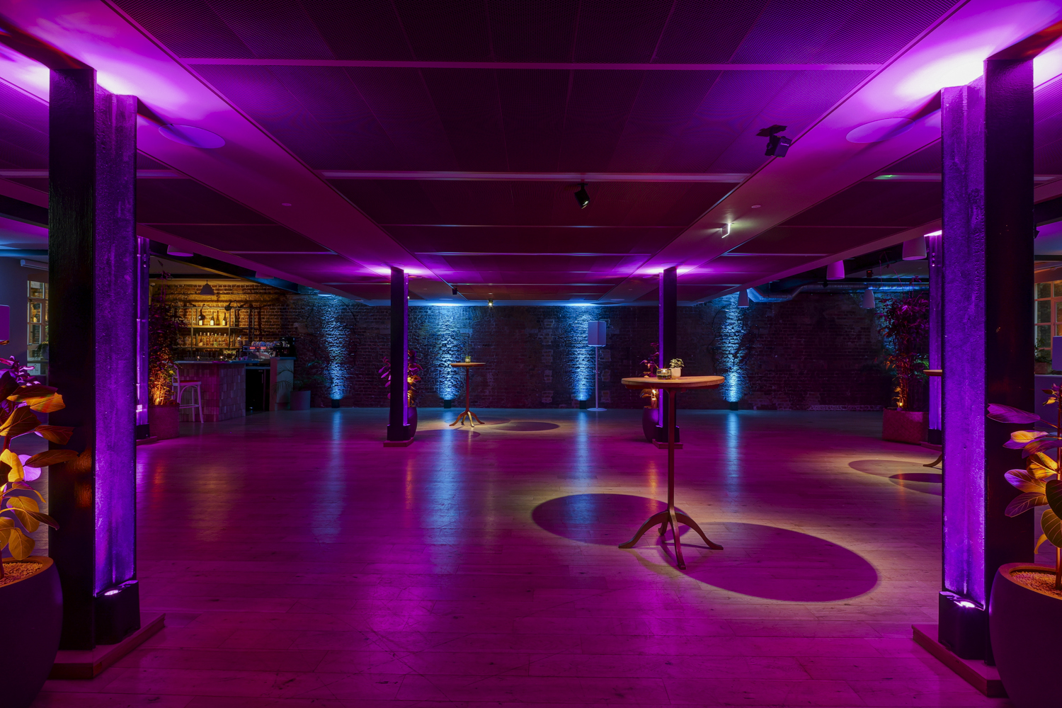 Stylish event space at The Forum with vibrant purple lighting for corporate gatherings.