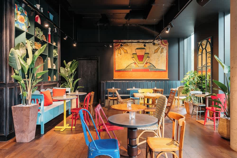 Vibrant Ruby Zoe Hotel bar with colorful furniture, ideal for networking events.