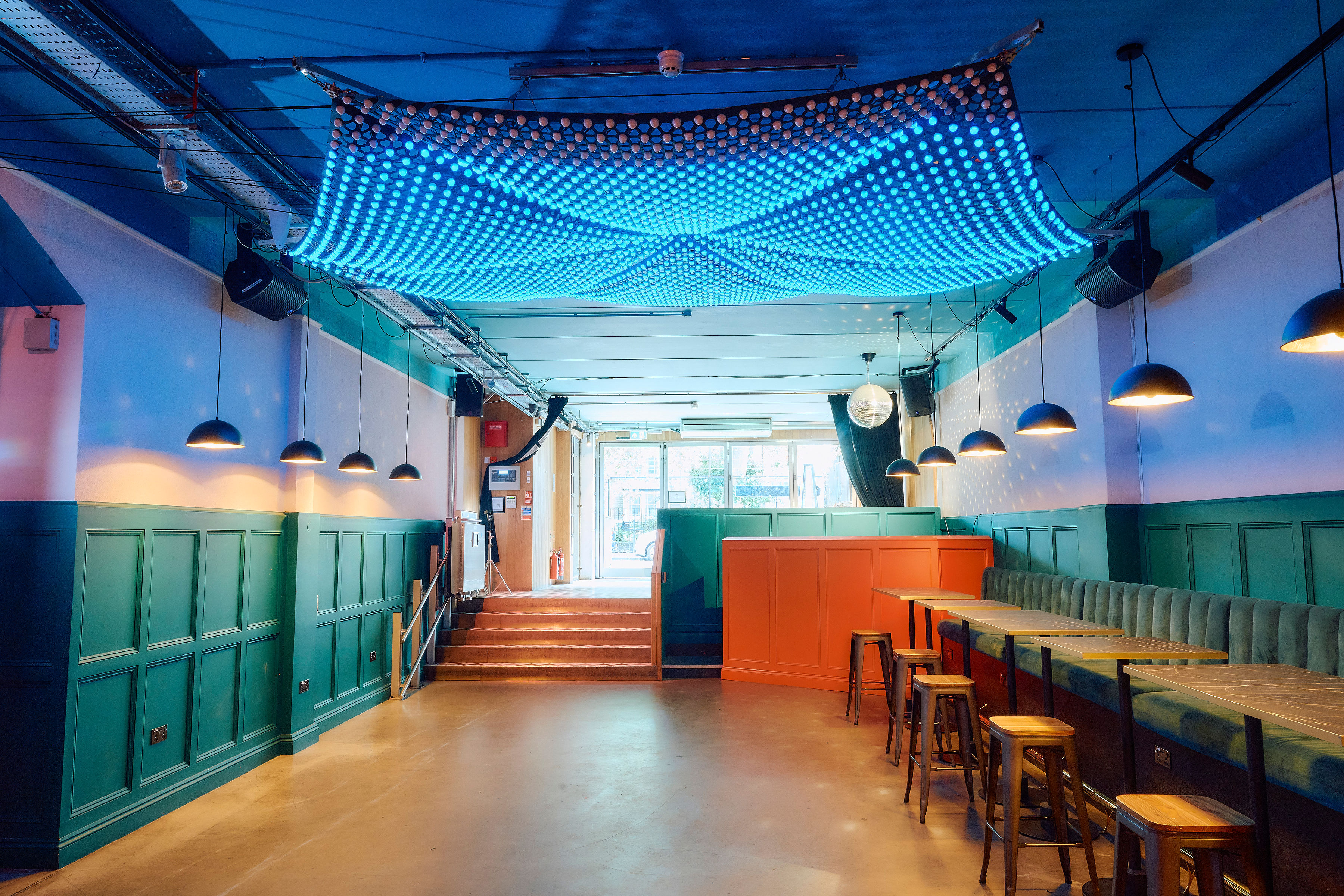 Main Bar & Terrace at Colours Hoxton, modern event space with blue lighting, ideal for gatherings.