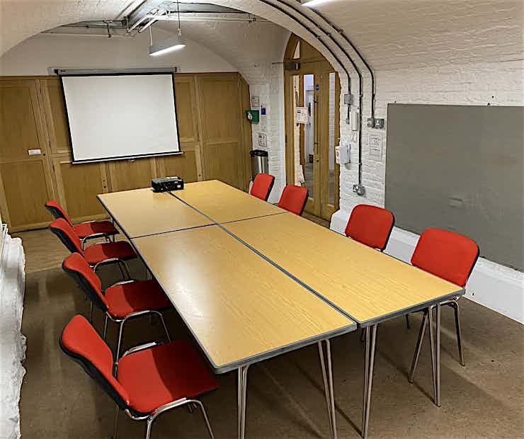 Interview Room at Barnsbury Centre with red chairs, ideal for meetings and presentations.