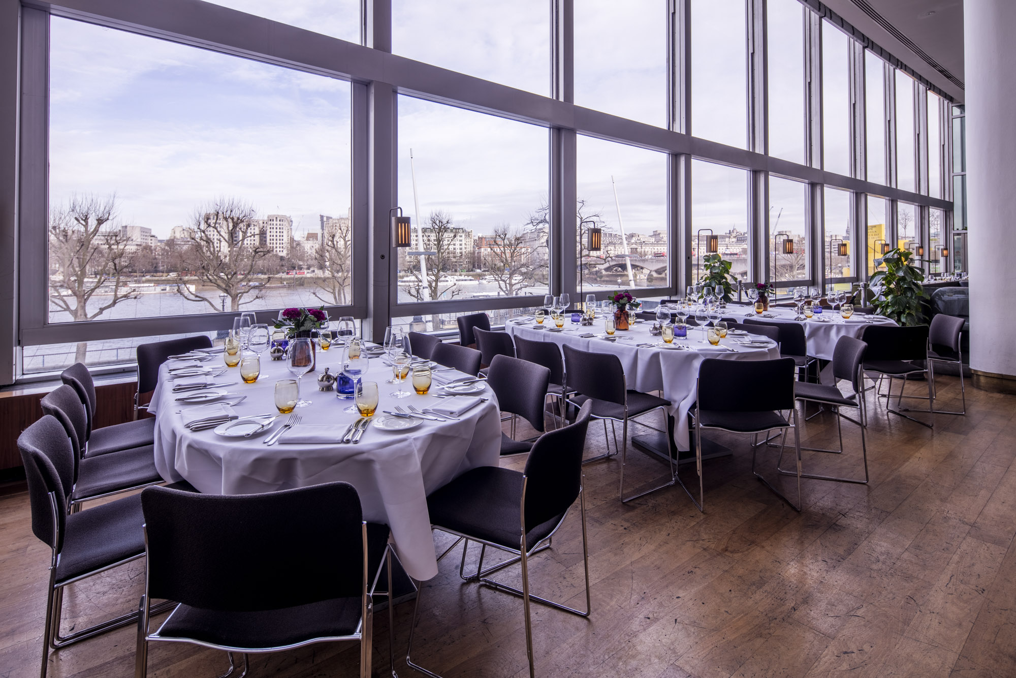 Elegant dining setup with round tables and scenic views for corporate events.