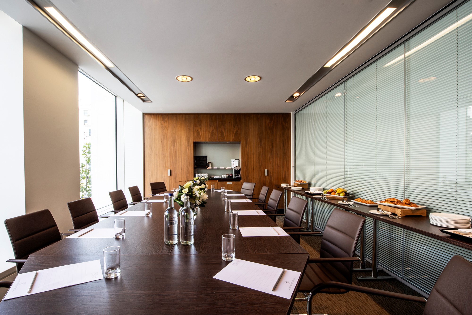 Modern conference room with long table, ideal for meetings and corporate events.