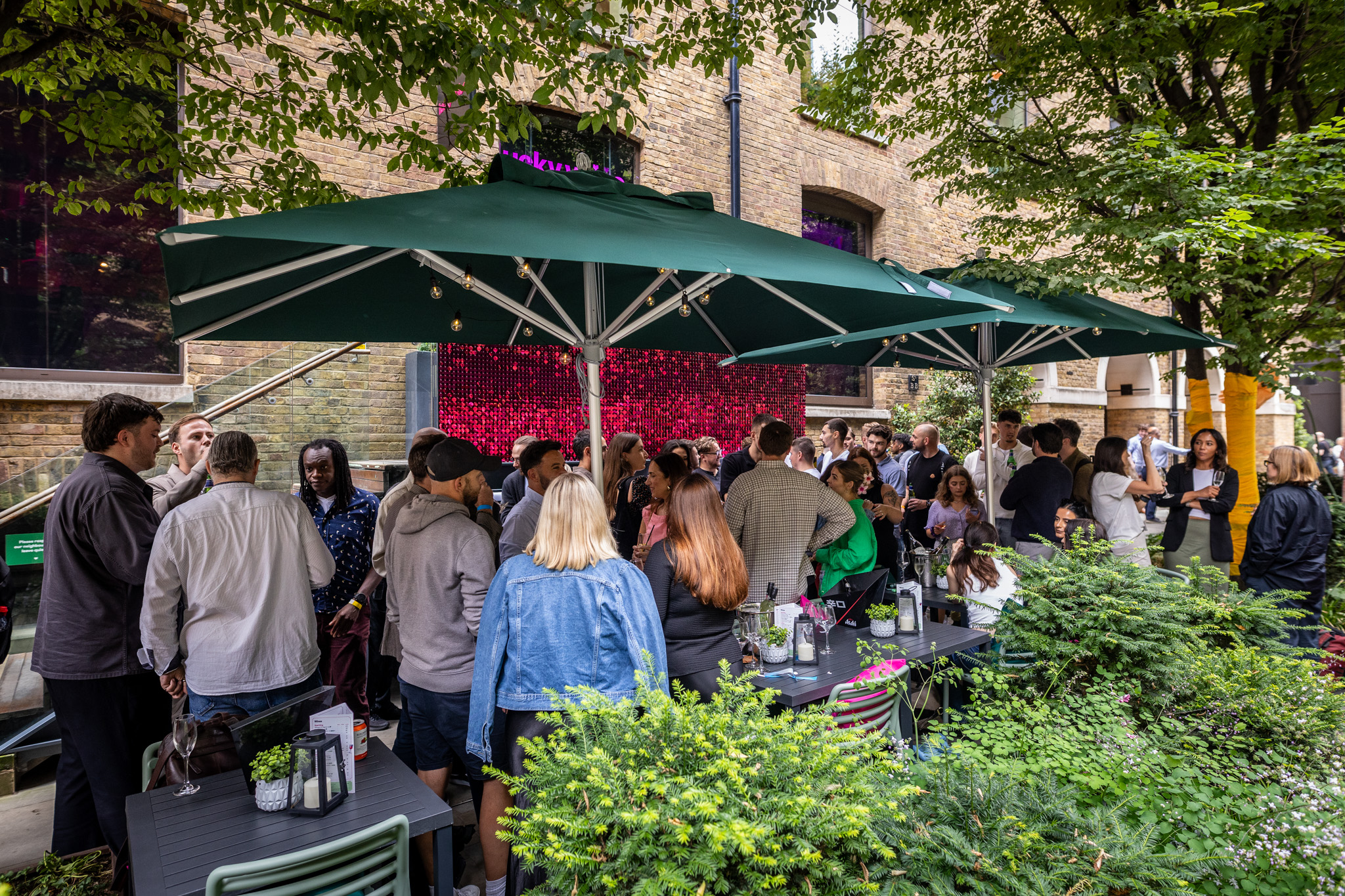 Vibrant outdoor networking event at Lucky Voice Liverpool Street with stylish umbrellas.