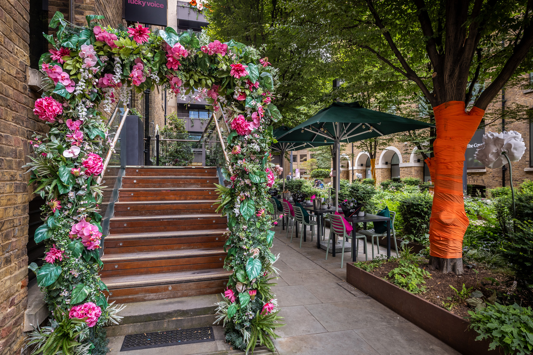 Floral arch entrance at Lucky Voice Liverpool Street for outdoor events and gatherings.