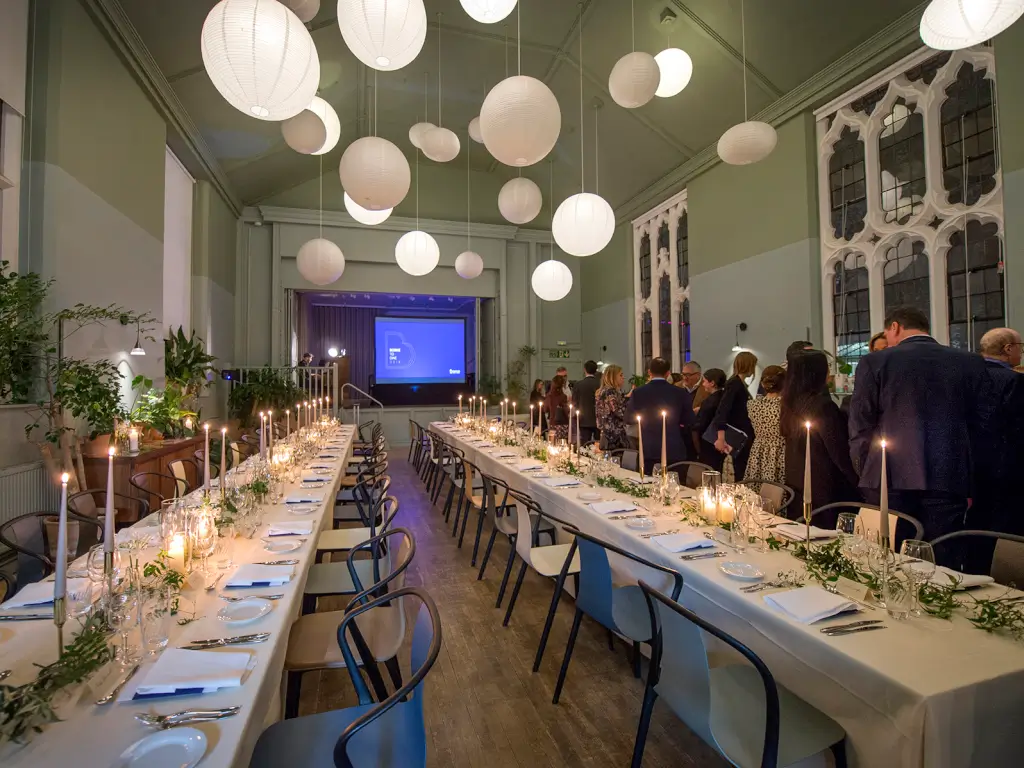 Elegant dining setup with candles at Refettorio Felix for networking event.