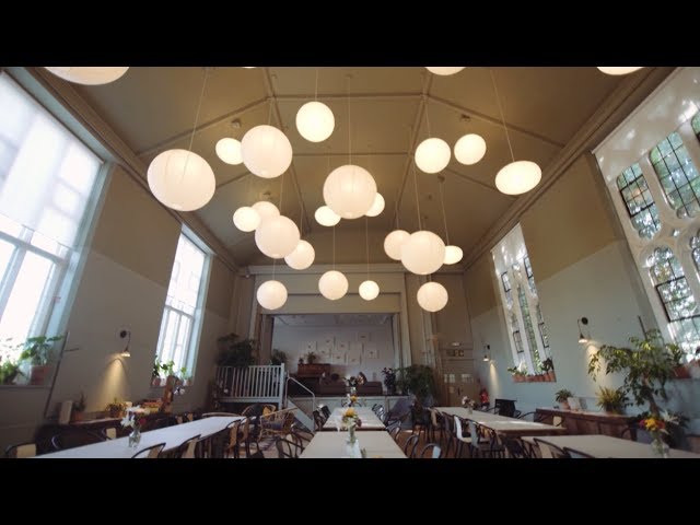 Spacious event venue with pendant lighting, ideal for meetings and gatherings.