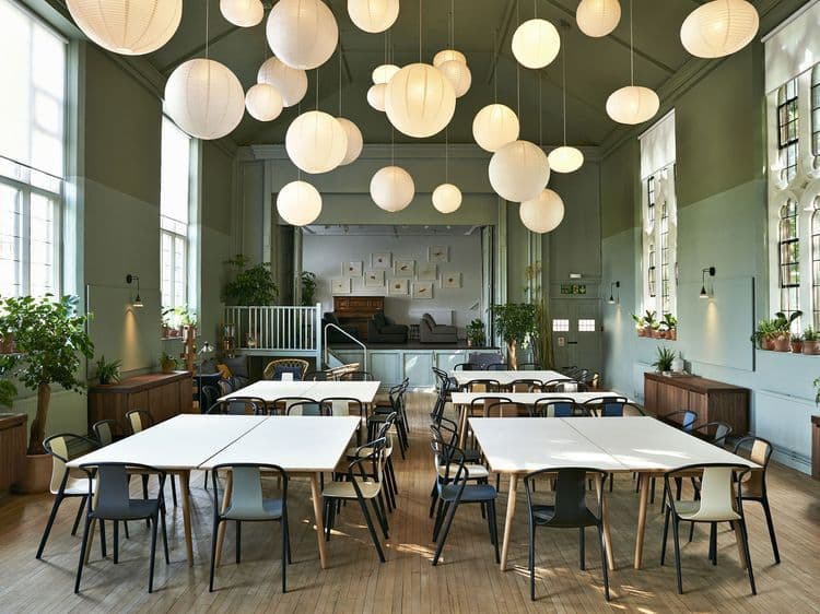 Versatile event space at Refettorio Felix with soft lighting for workshops and gatherings.