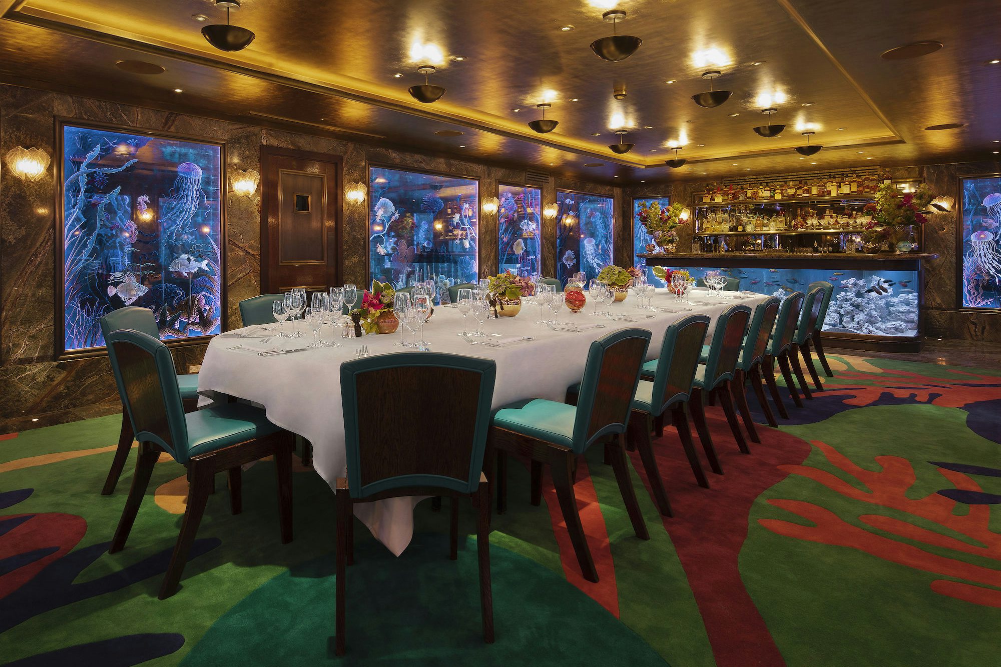 Elegant dining space with aquarium backdrop for exclusive events and corporate dinners.