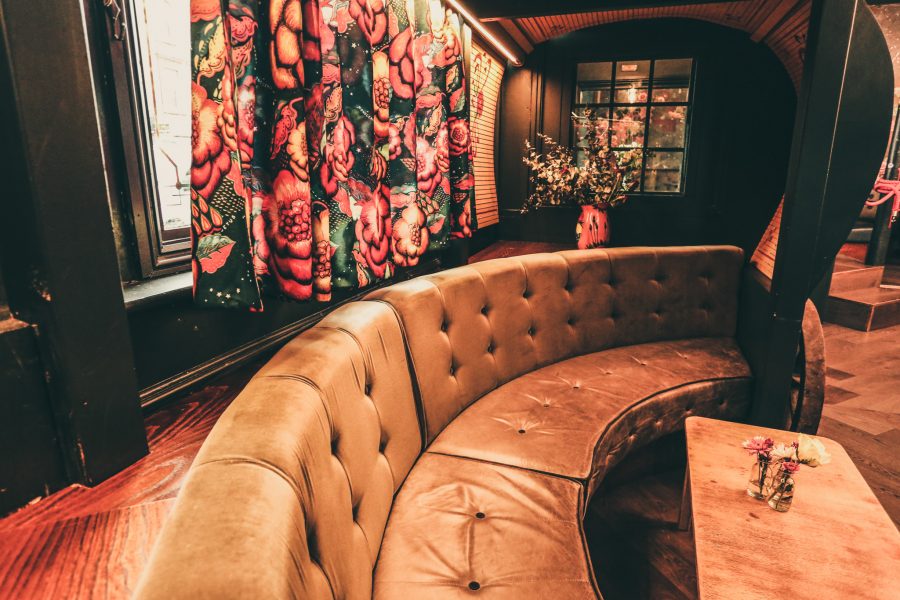 Cozy seating area with curved leather bench for networking events at Star of Bethnal Green.