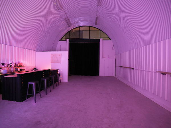 Indoor event space with curved ceiling, perfect for social gatherings and creative events.
