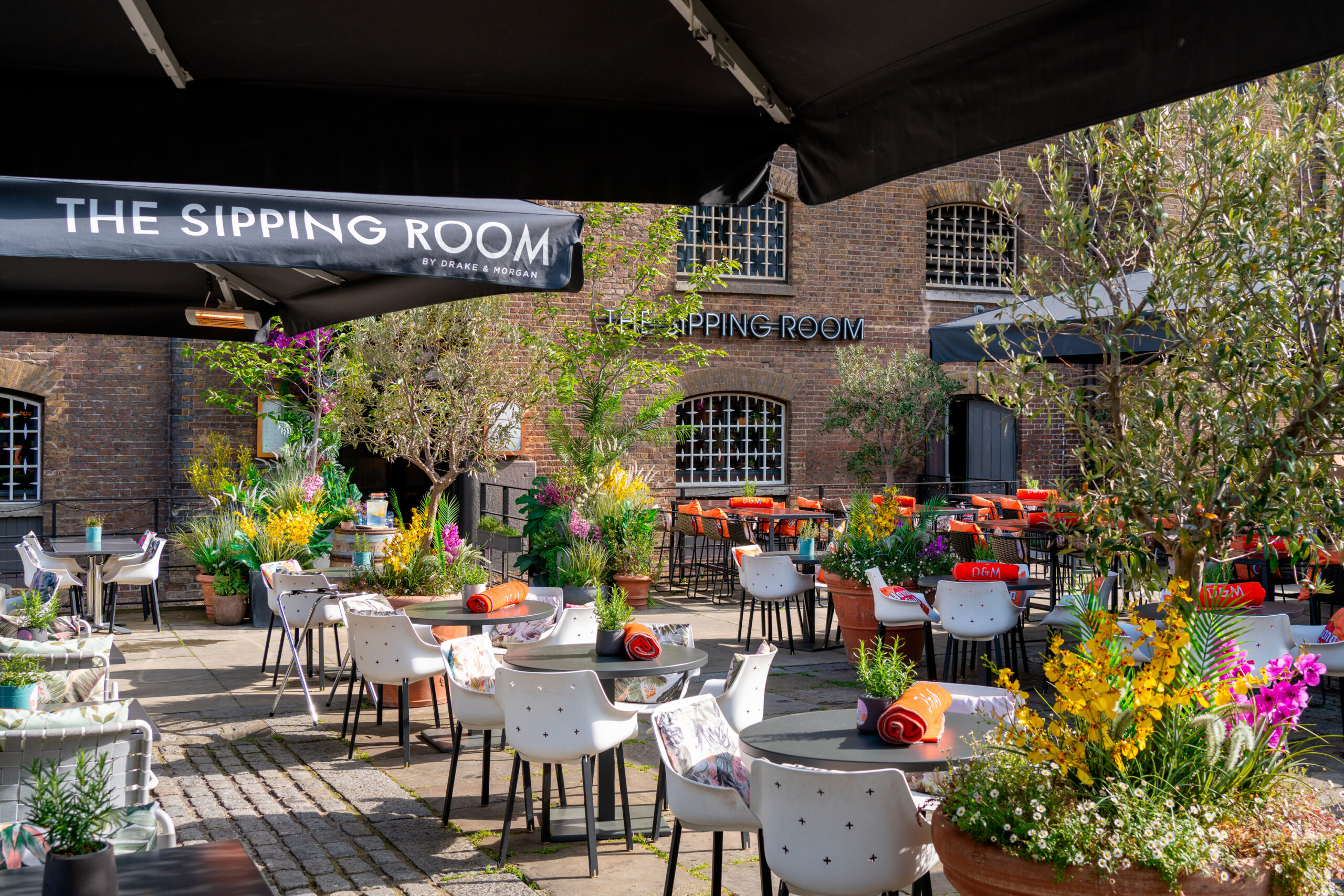 Private booths with floral decor at The Sipping Room, ideal for outdoor events and gatherings.