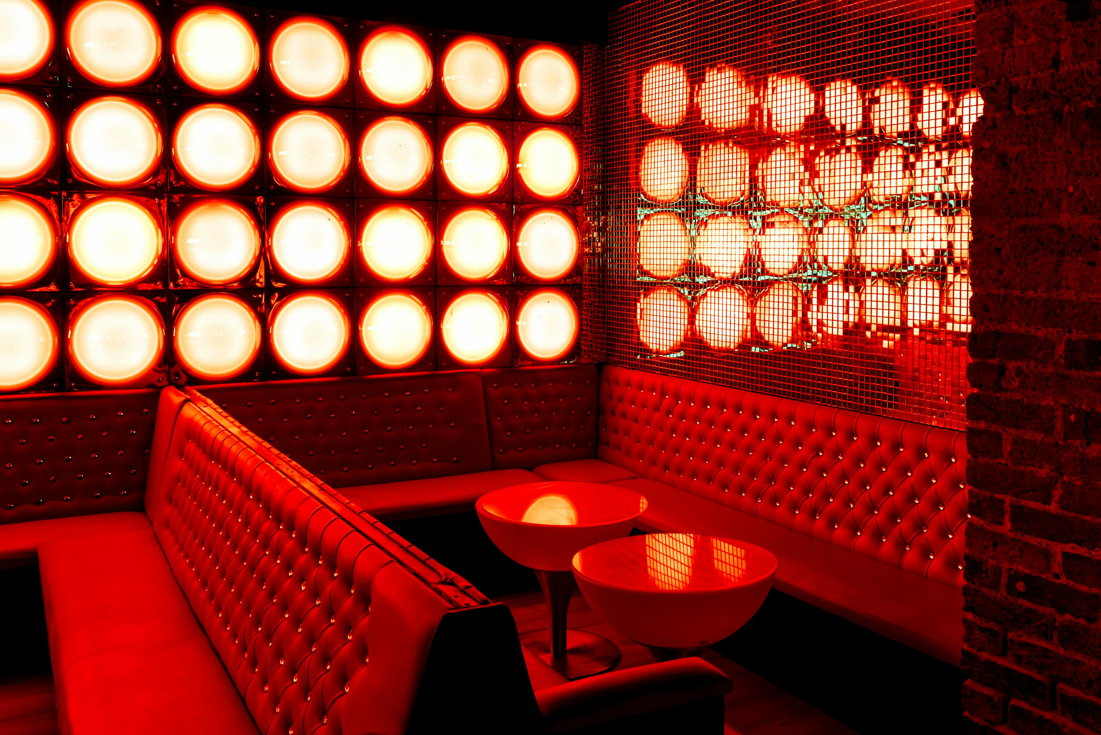 Vibrant lounge bar with red lighting, ideal for networking events and private gatherings.