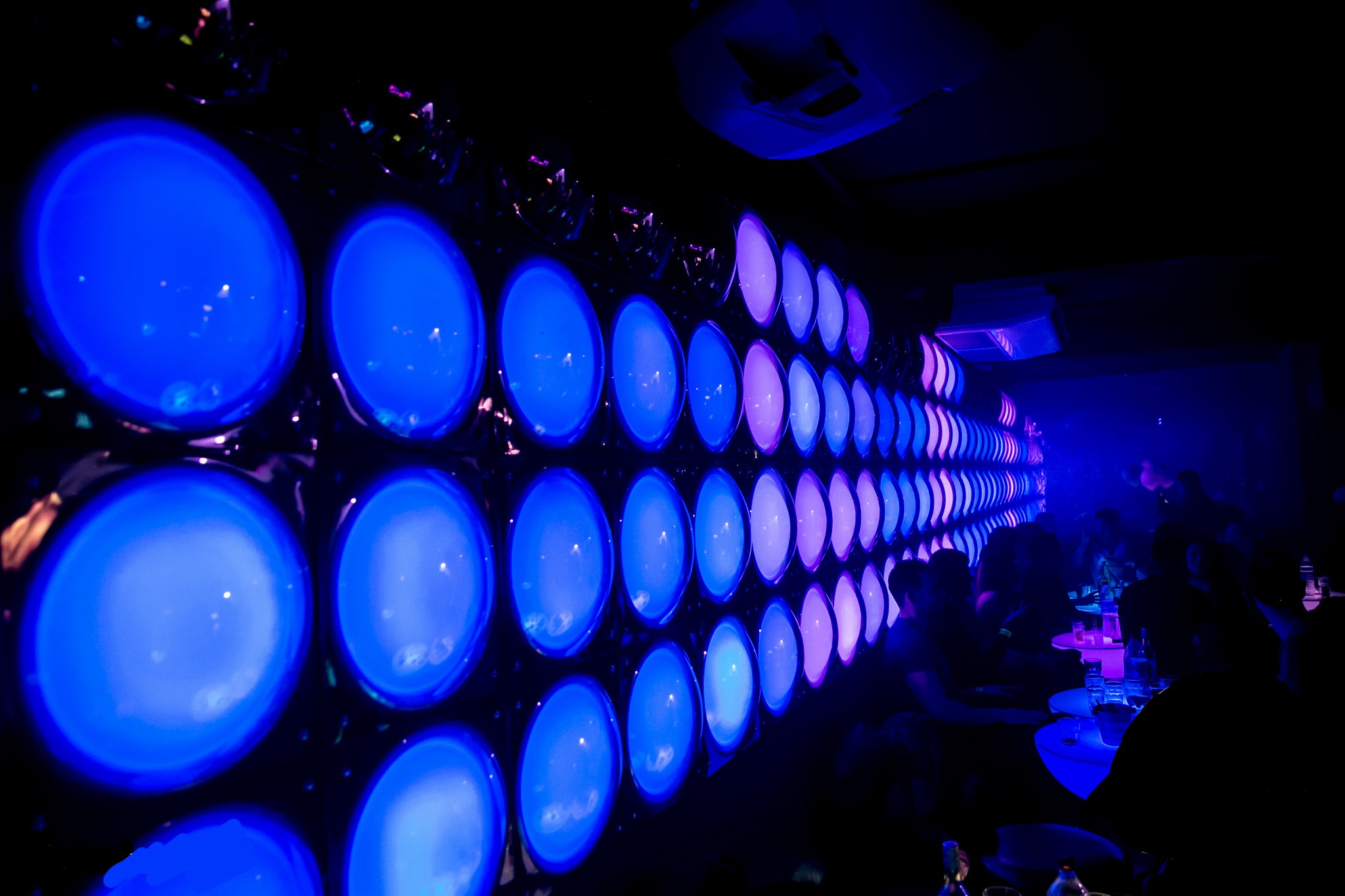 Vibrant bar with circular light panels, perfect for parties and corporate events.