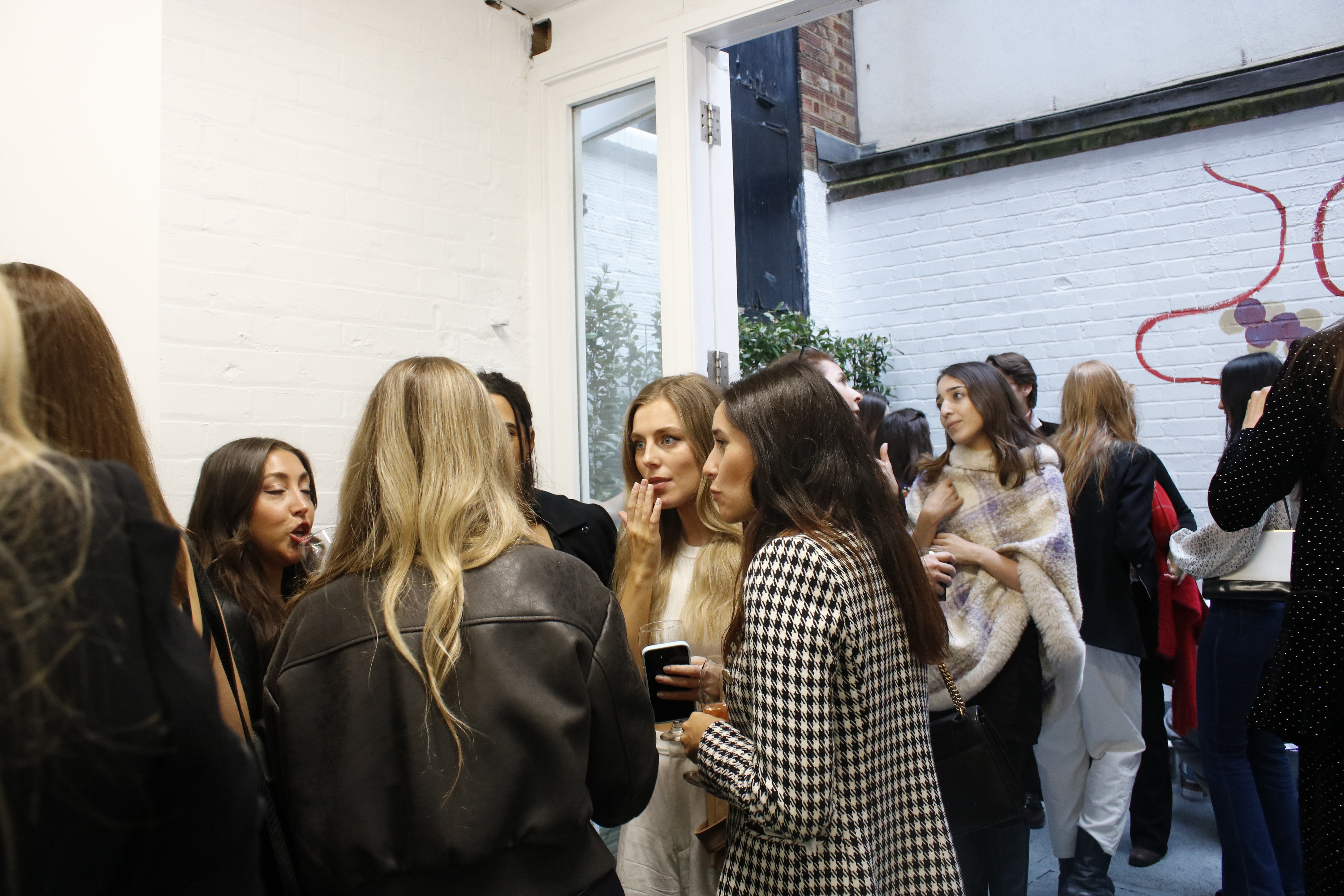 Vibrant networking event in Fitzrovia Gallery with stylish attendees and natural light.