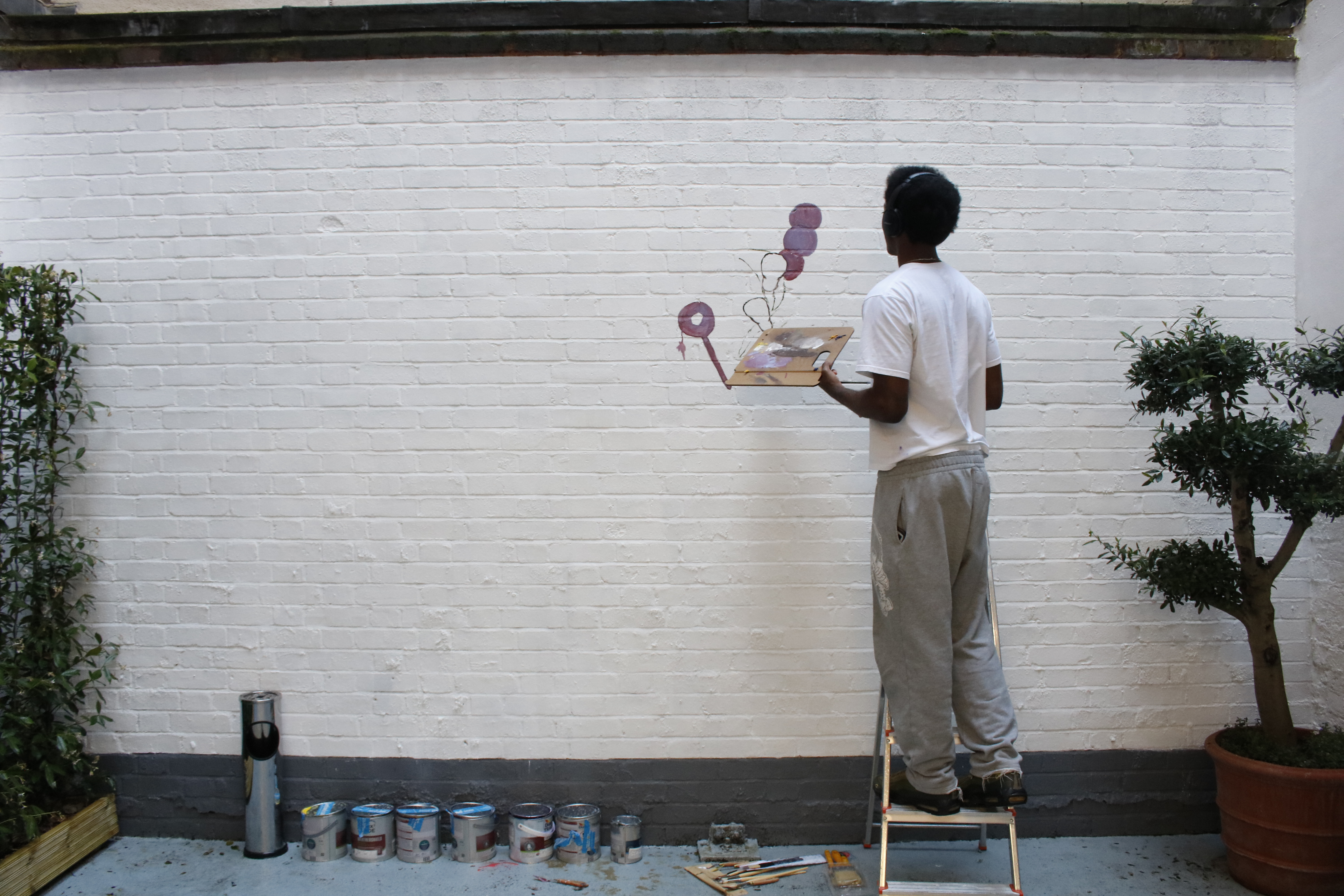 Artist painting mural in Fitzrovia Gallery for creative event ambiance and engagement.