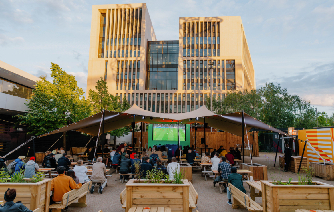 Outdoor event setup at The Yard, featuring a large tent and modern building backdrop.