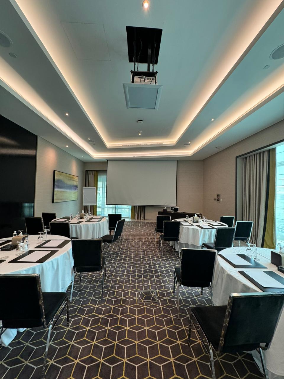 Meeting room in Fairmont Riyadh with round tables, ideal for corporate events and workshops.