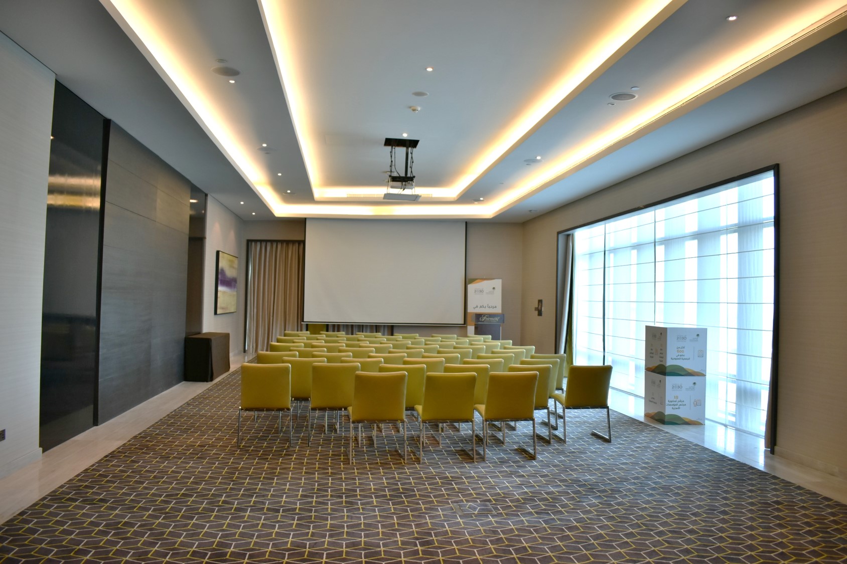 Meeting room in Fairmont Riyadh with yellow chairs for presentations and events.