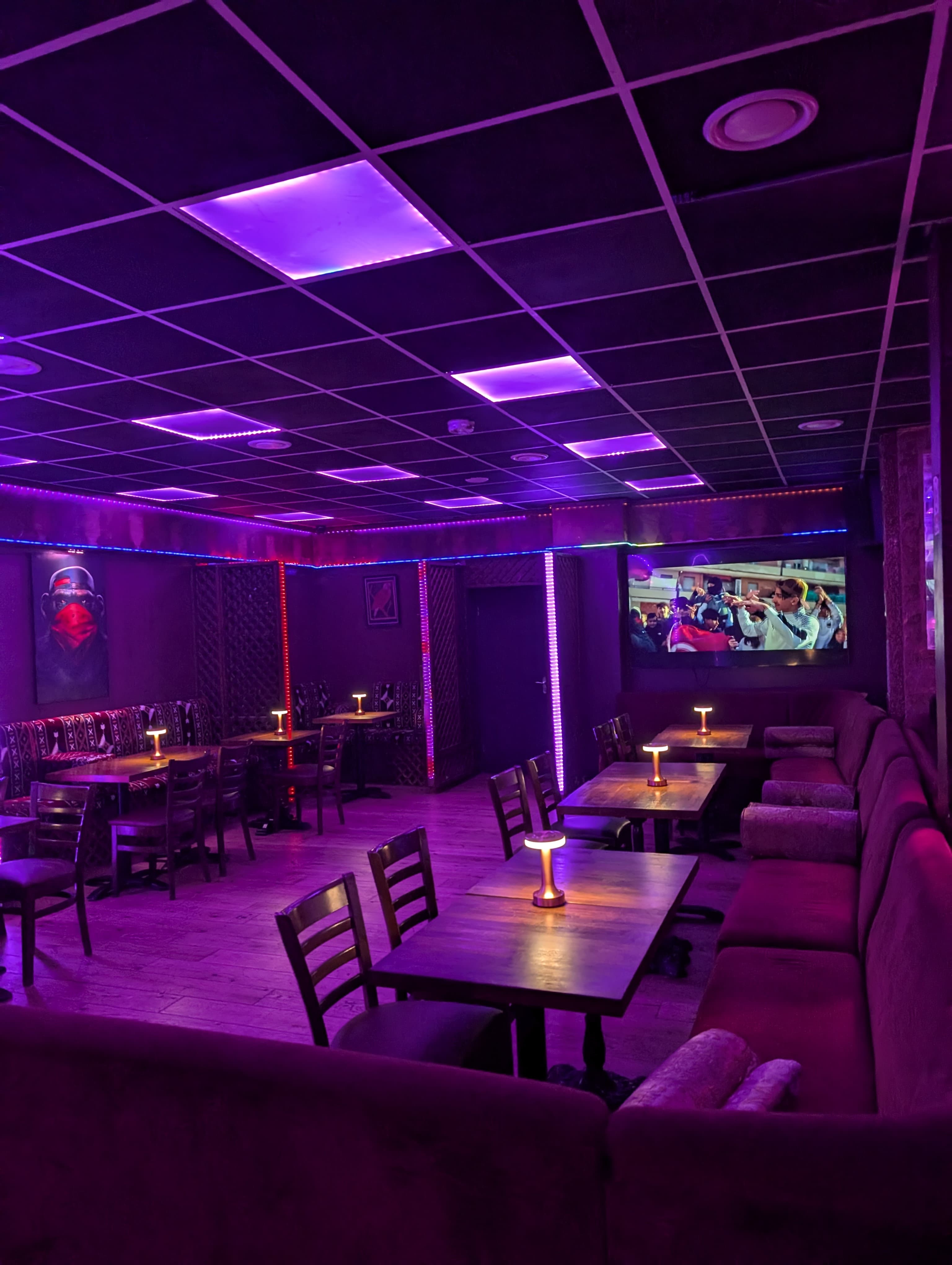Modern event space with purple lighting, ideal for intimate gatherings and themed parties.