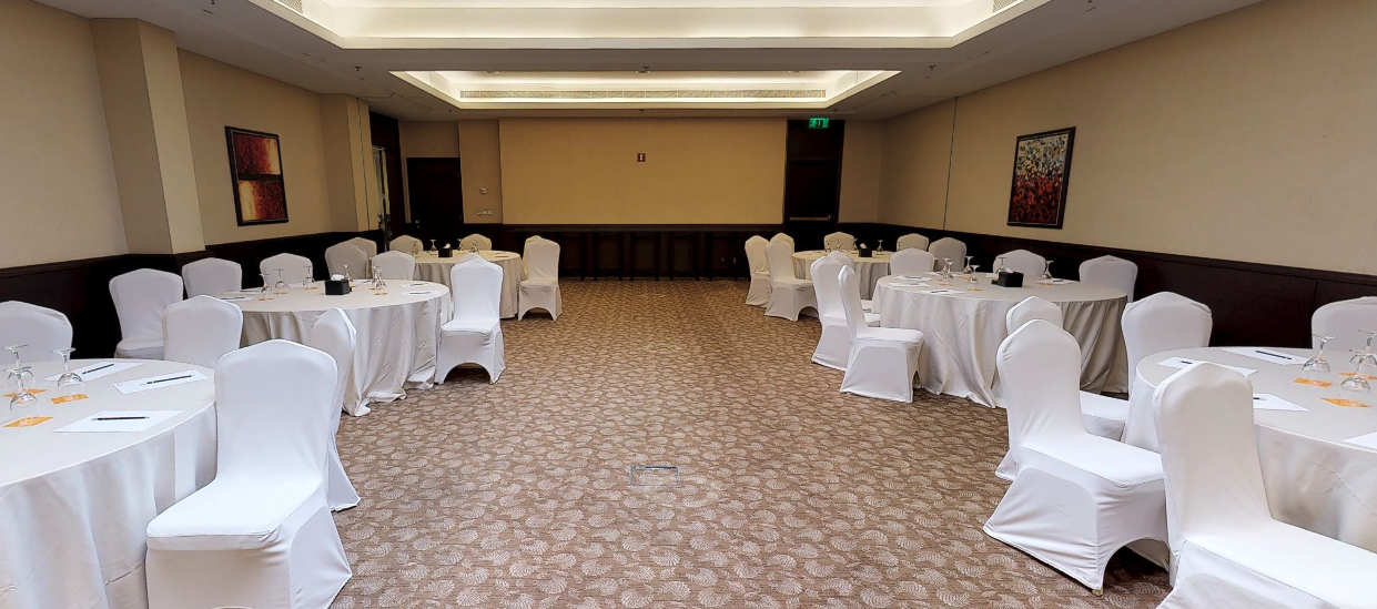 Asafeer meeting space with round tables, ideal for conferences and workshops.