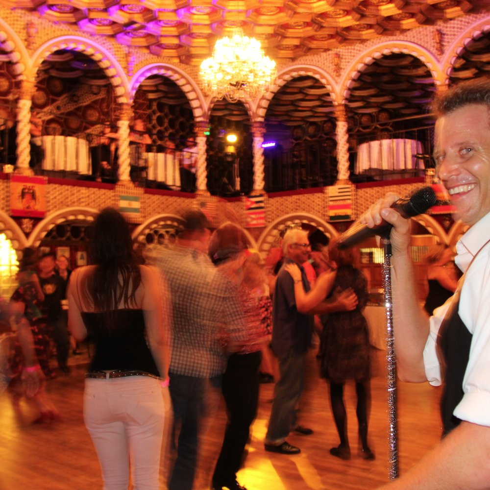 Vibrant Champion Ballroom at Firehouse Swing Dance with lively crowd and colorful lighting.