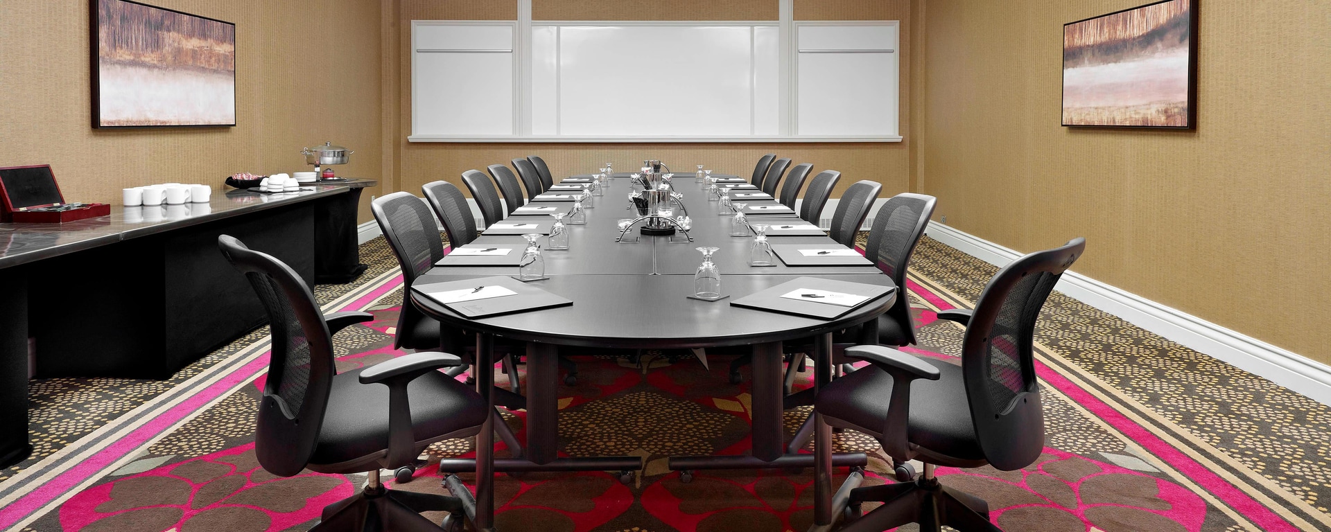 Professional meeting room with oval table and ergonomic chairs for corporate events.